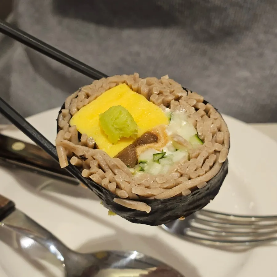 A piece of buckwheat gimbap topped with wasabi