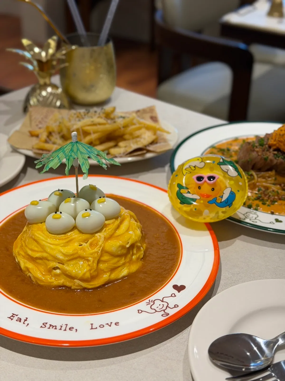 Rubber-duck omurice and gochujang butter pasta together on the table