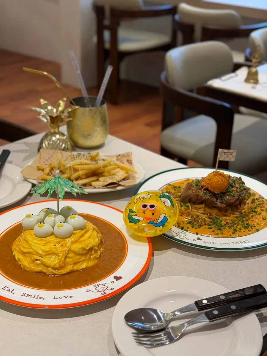Table filled with omurice, pasta, fries, and ade