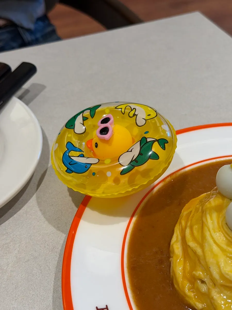 Omurice decorated with a palm tree, rubber duck, and tube