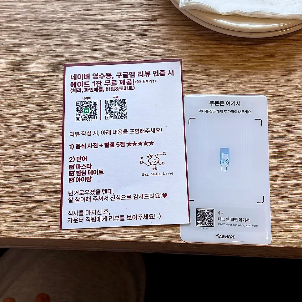 테이블에 부착된 오밀 태그히어 주문 안내