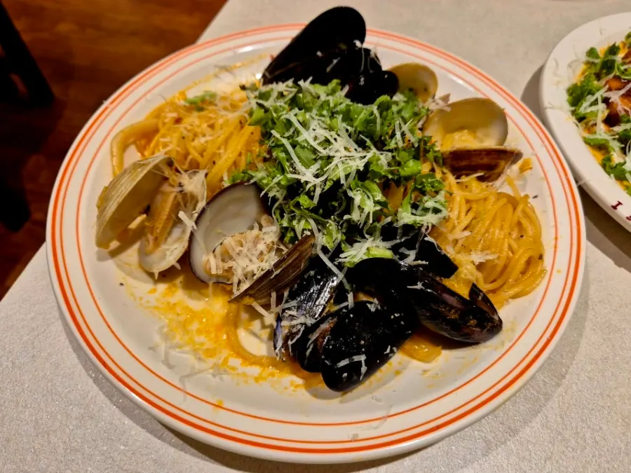 Two pasta dishes and drinks laid out on the table