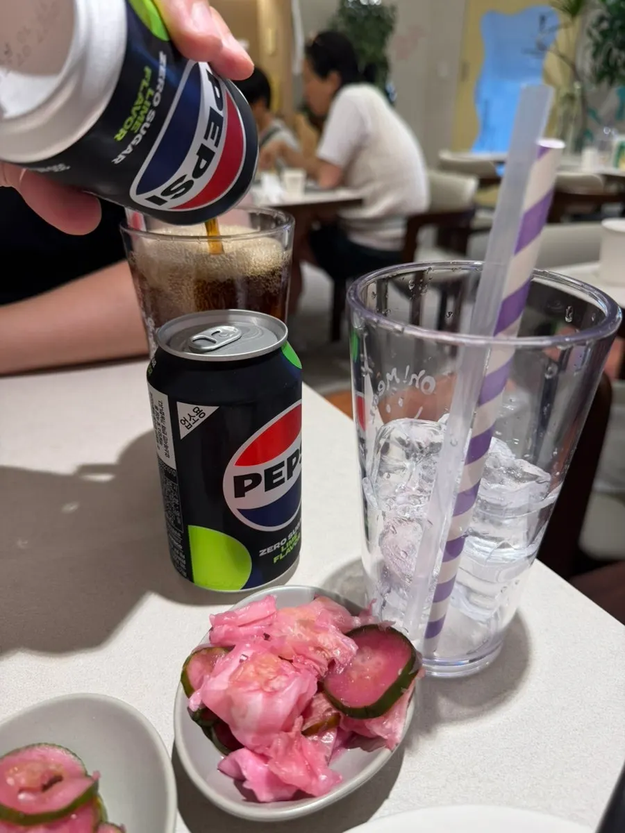 Self-service bar with water dispenser, cups, and pink pickles