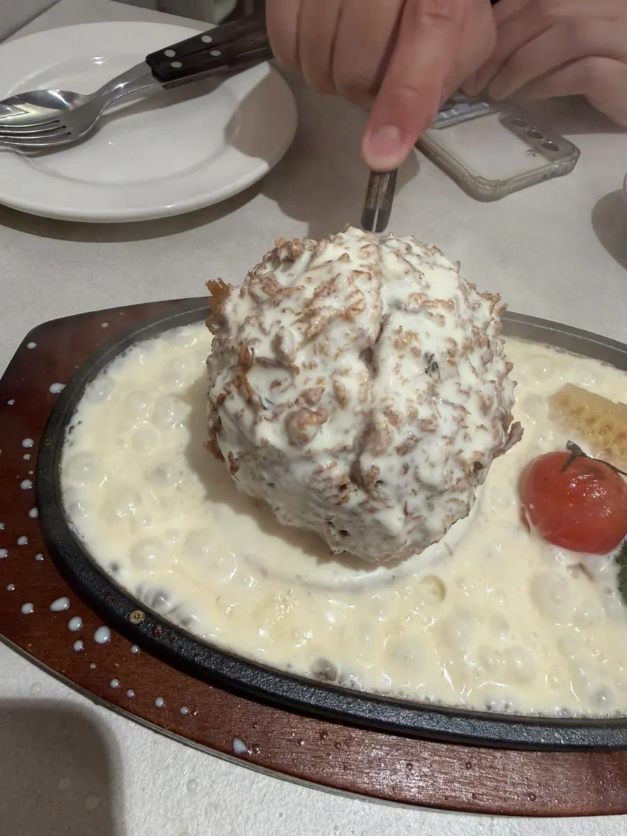A full plate of cheese katsu covered in cheese sauce