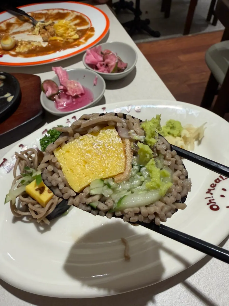 A bite of soba maki with pickles
