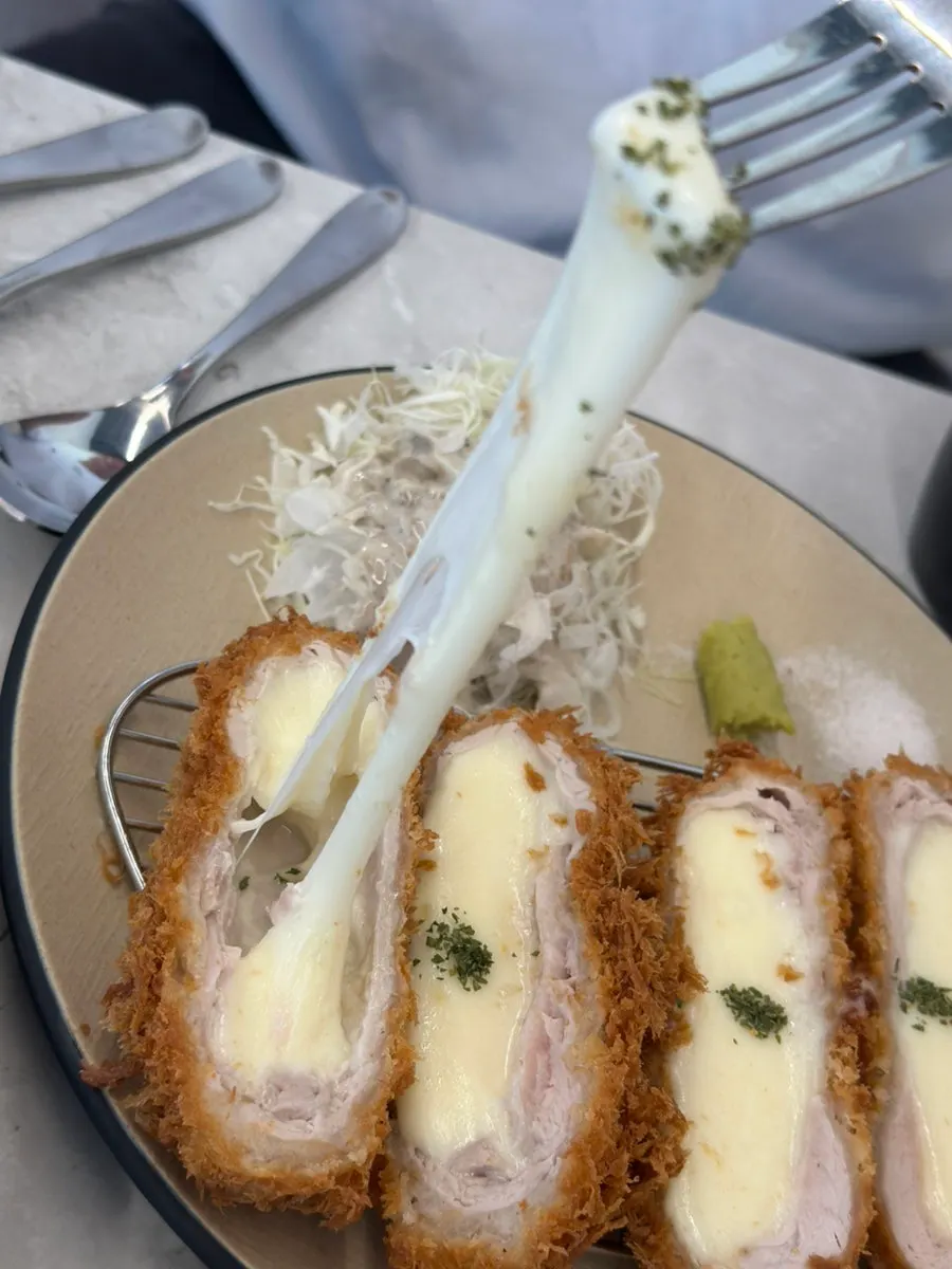 Cross-section of cheese katsu with melted cheese stretching out