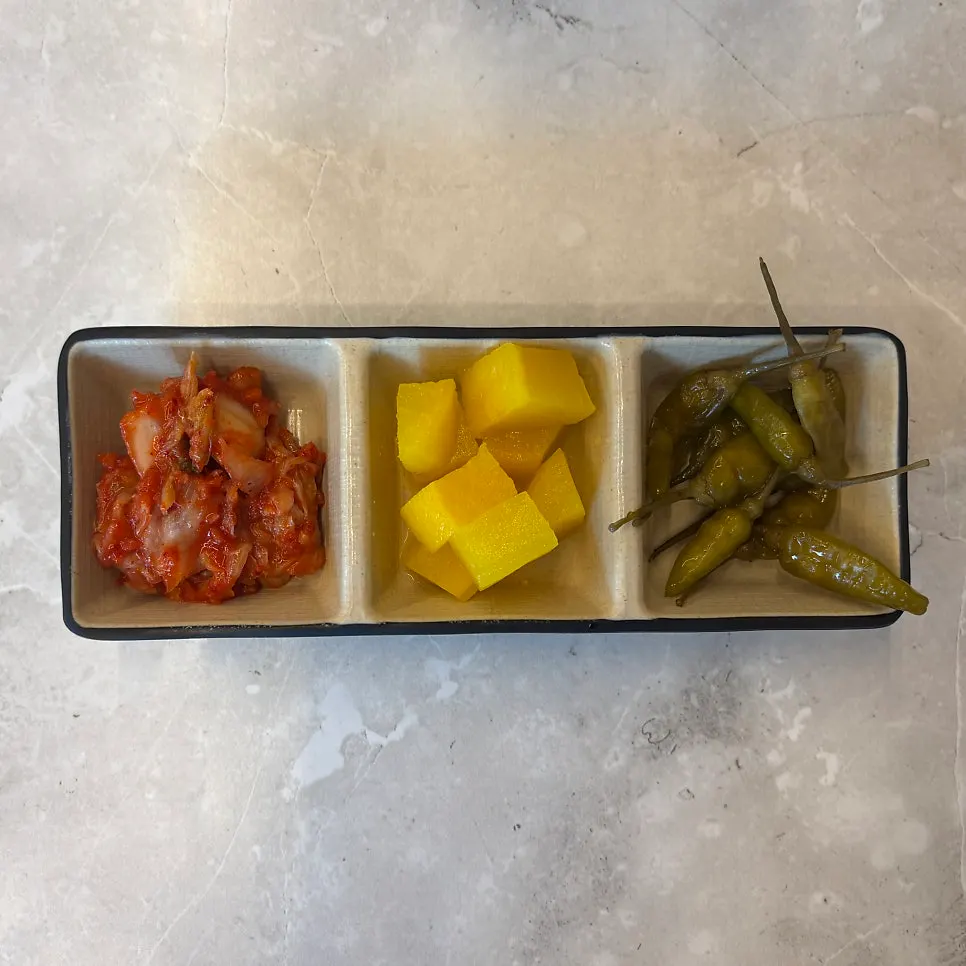 김치와 단무지가 놓인 오미카츠 반찬 셀프바