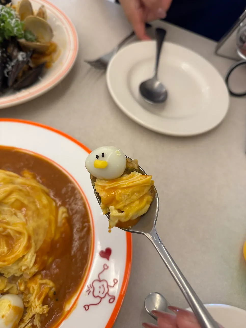 A spoonful of omurice dipped in curry sauce