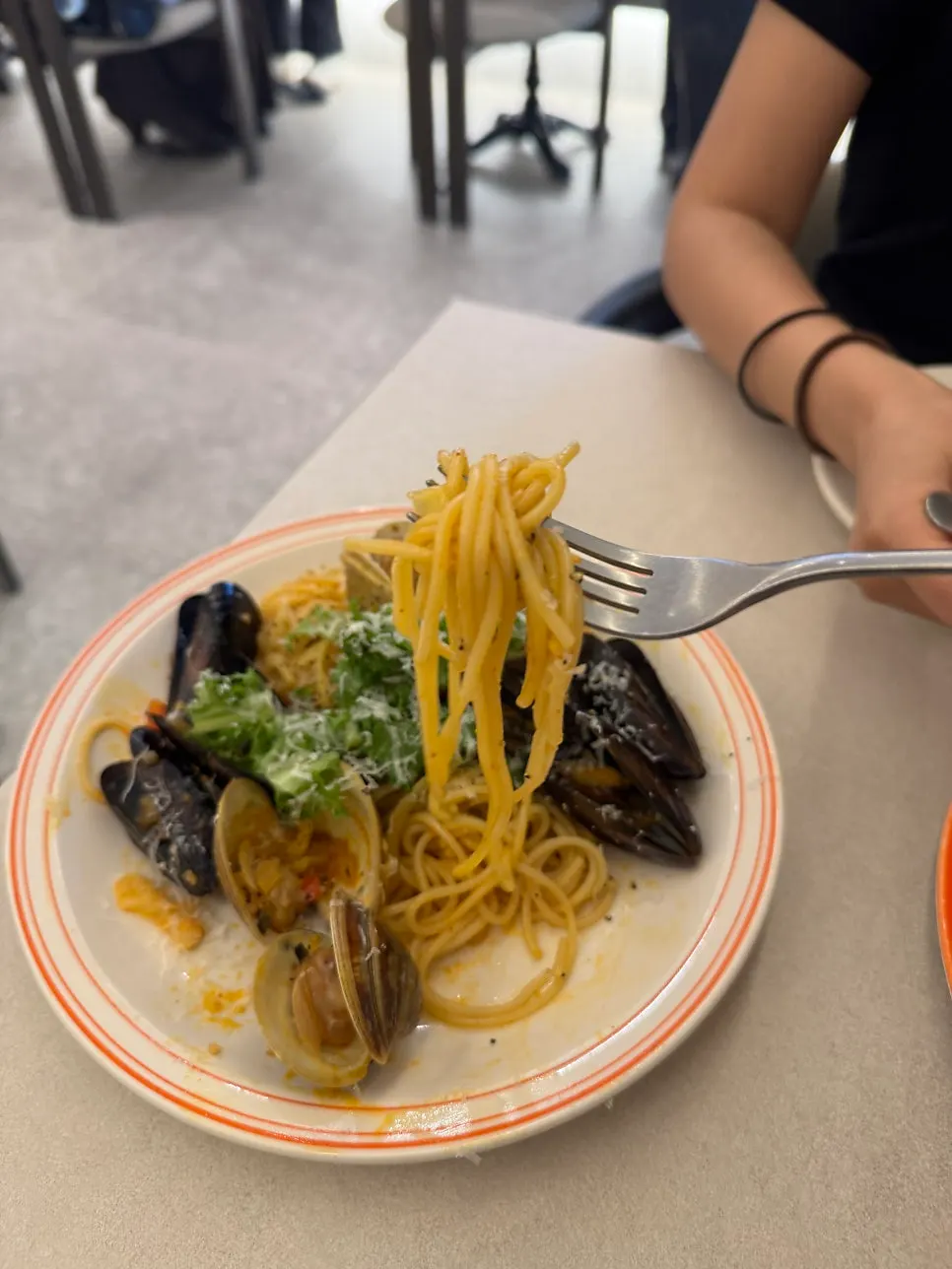 Seafood pasta sprinkled with arugula and grated cheese