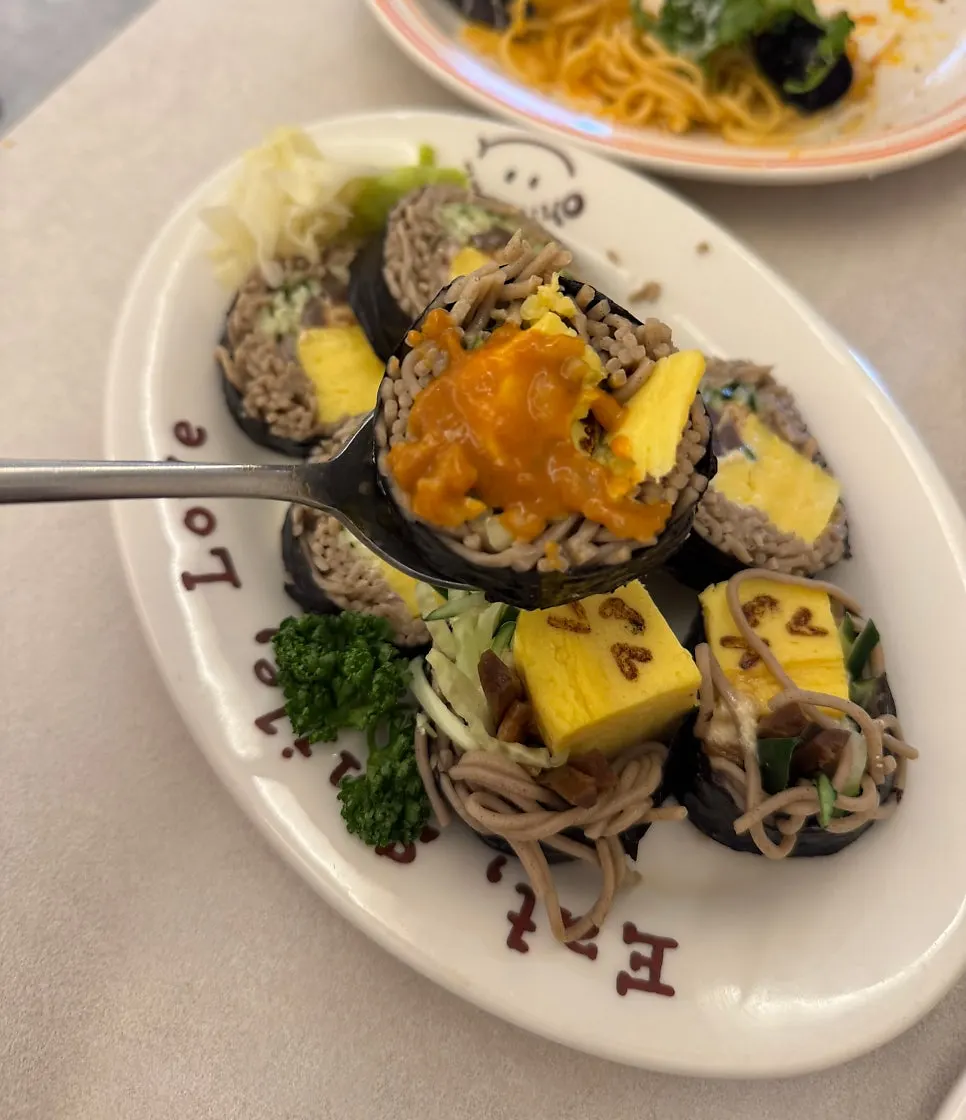 A piece of buckwheat gimbap dipped in curry sauce