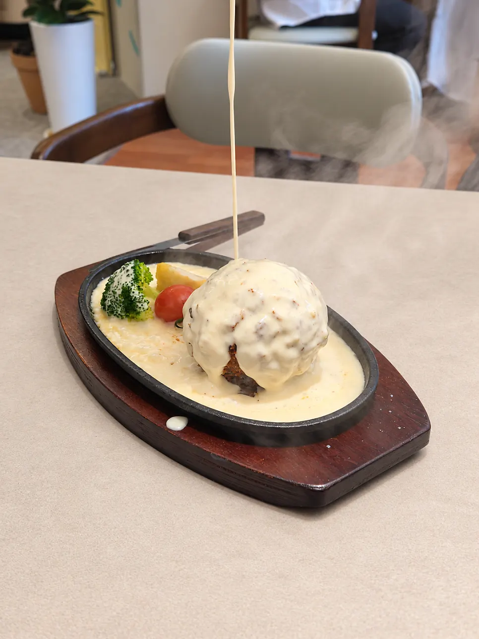 A staff member pouring cheese tableside as a performance