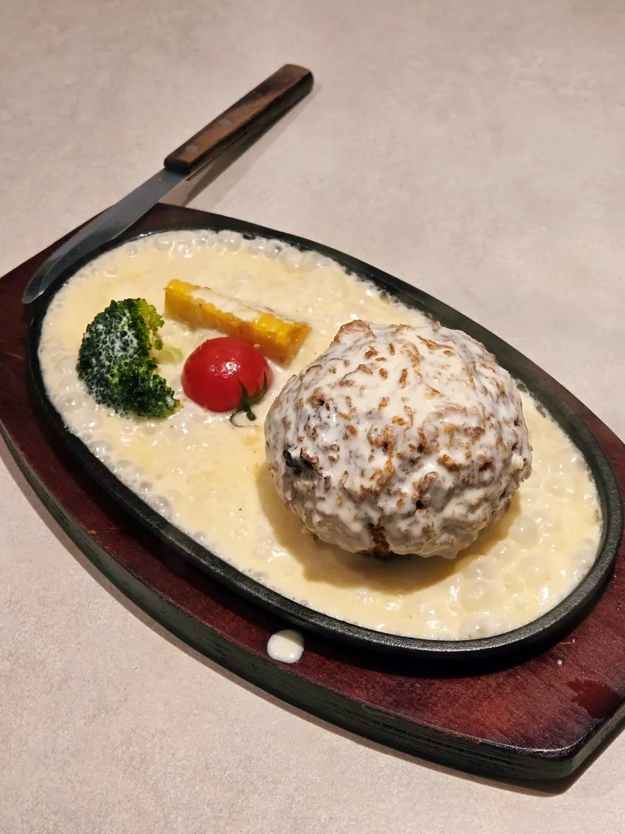 Cheese katsu sizzling on the hot plate