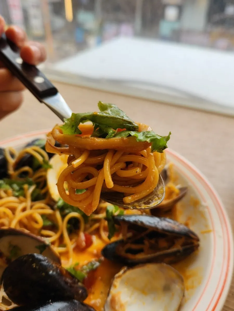 Spicy seafood oil pasta twirled on a fork