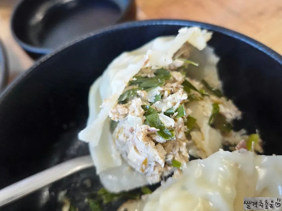 A steamed dumpling cut open to show the filling