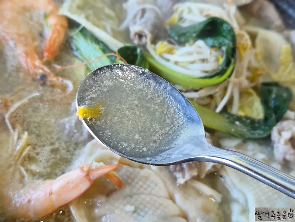 A ladle scooping up hot pot broth