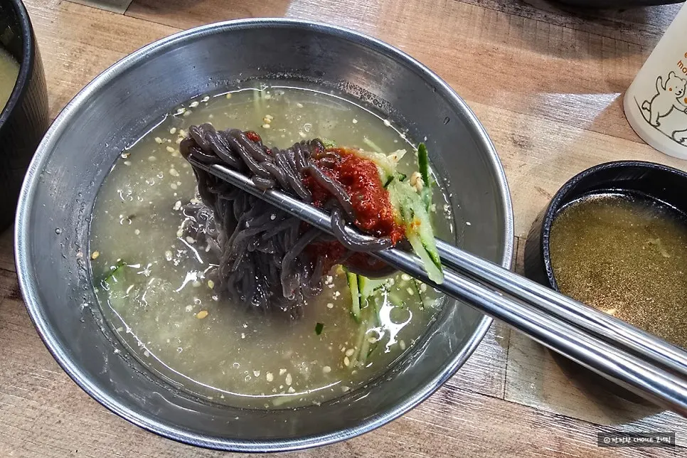 Sign describing Omi Omi's kudzu naengmyeon and a bowl of the noodles
