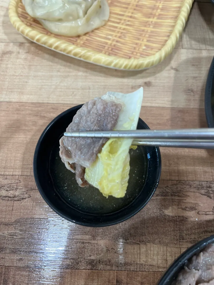 Glass noodles and vegetables lifted out of the hot pot