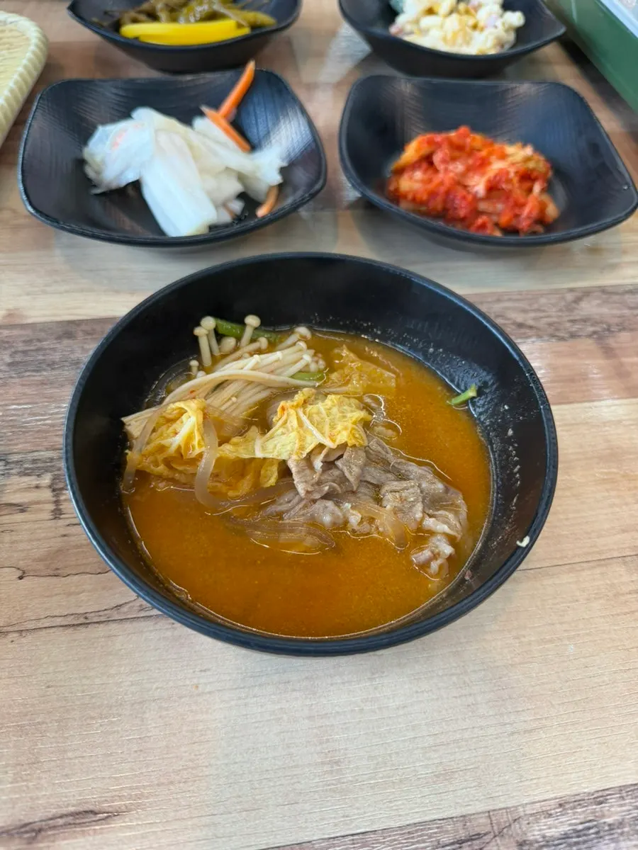 A handmade steamed dumpling cut in half showing the filling