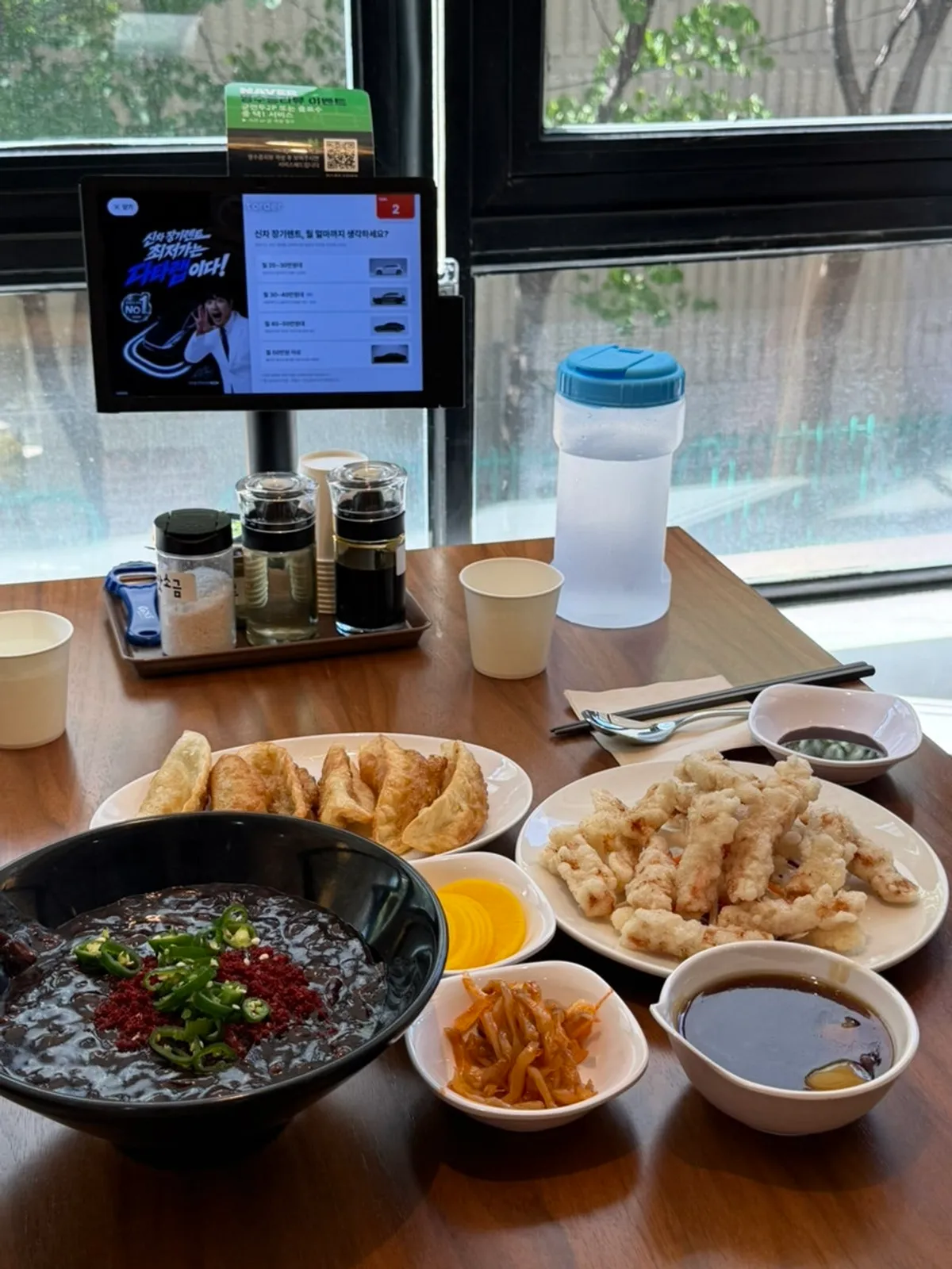 A full spread of chili jjajangmyeon, fried dumplings, and mini tangsuyuk