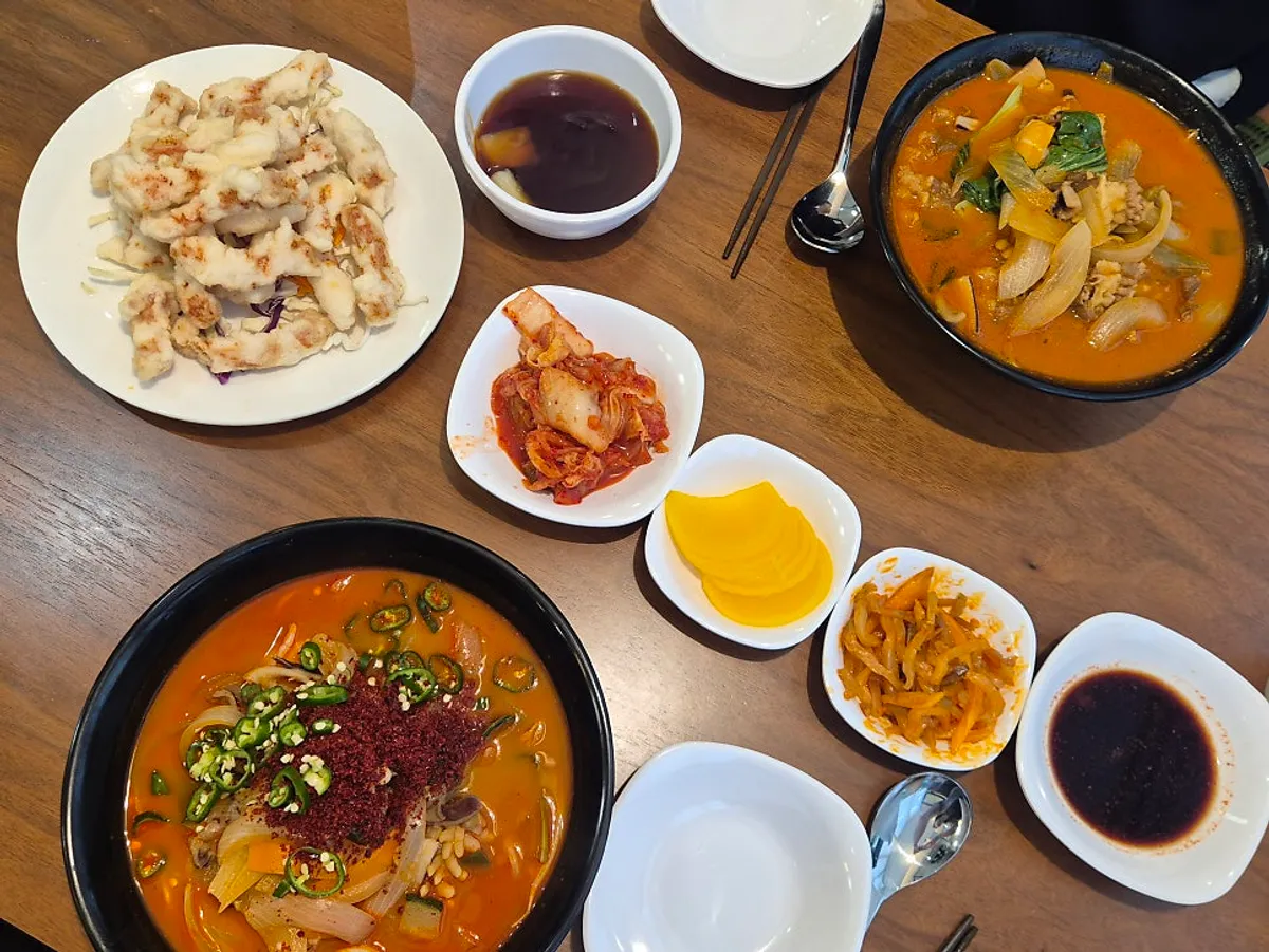 Table full of chili jjampong, beef jjampong, and mini tangsuyuk