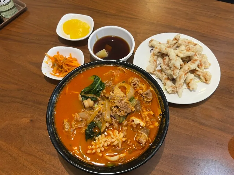 Full table spread of the bone-broth seafood jjampong and small tangsuyuk