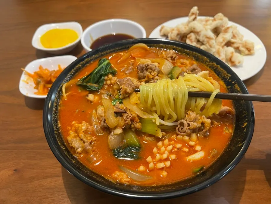 Jjampong noodles lifted with chopsticks