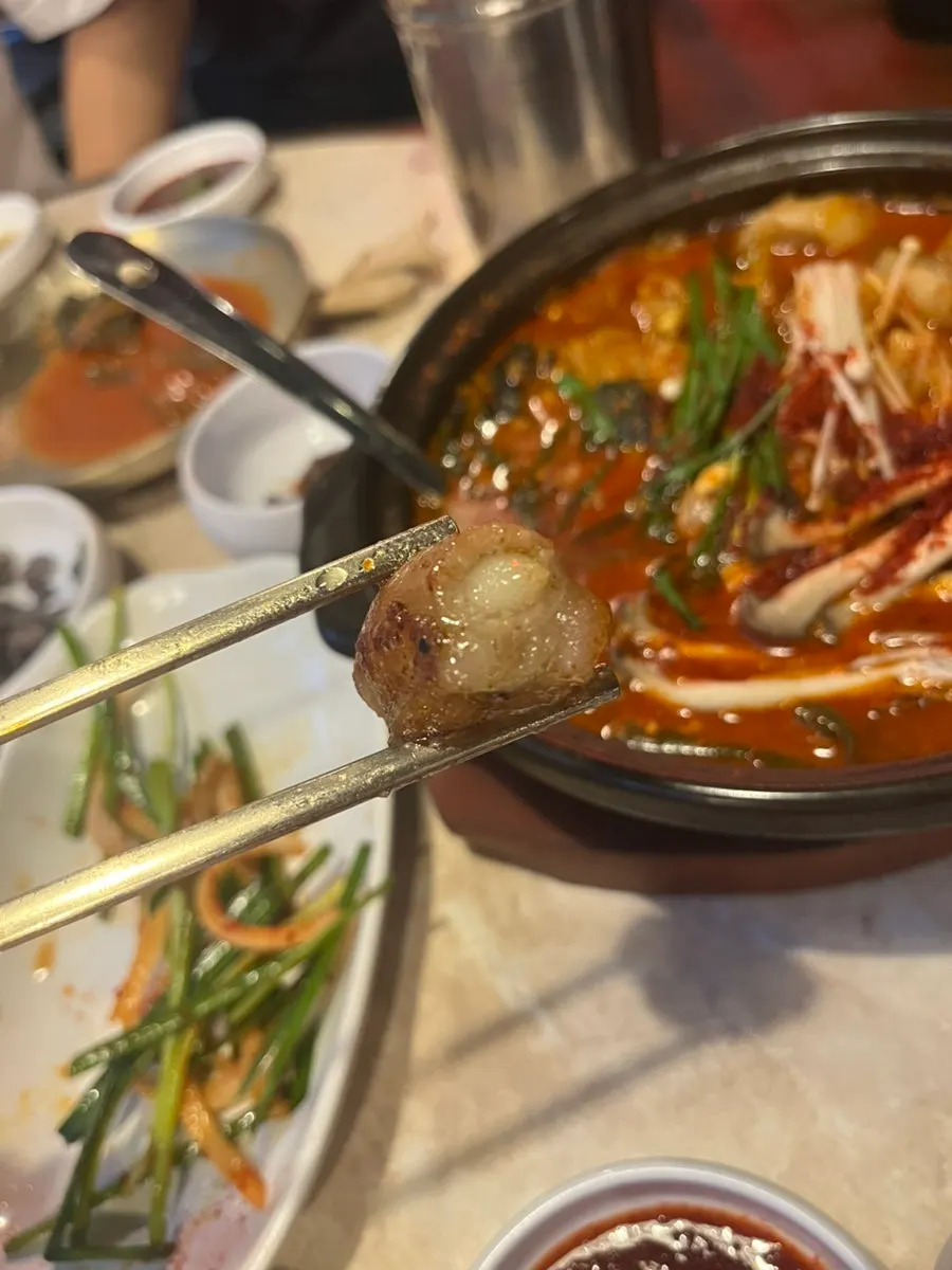 A piece of gopchang picked up with tongs