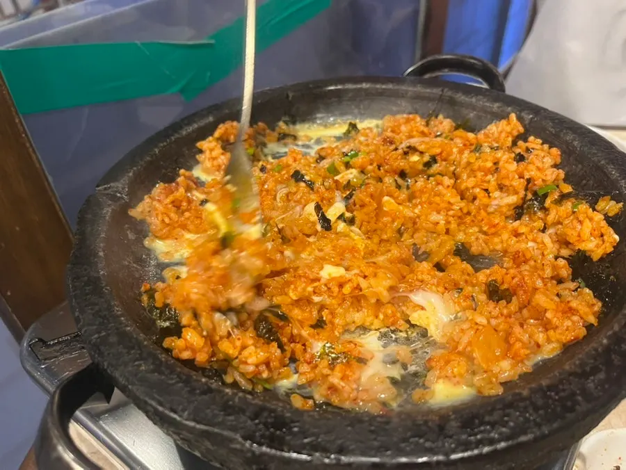 Fried rice spread out and pressed down to cook