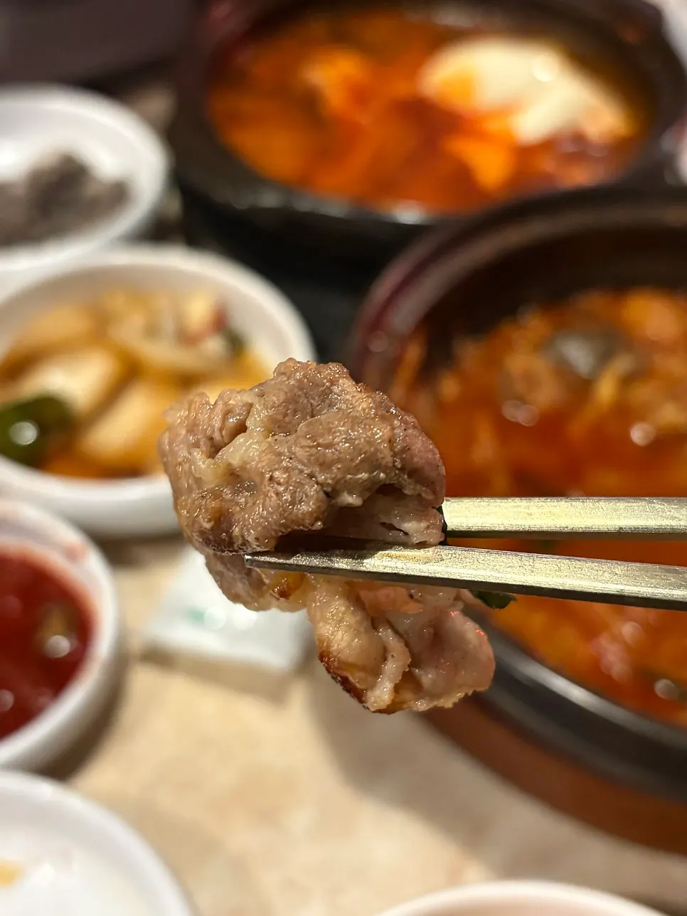 A single piece of garlic gopchang picked up with chopsticks