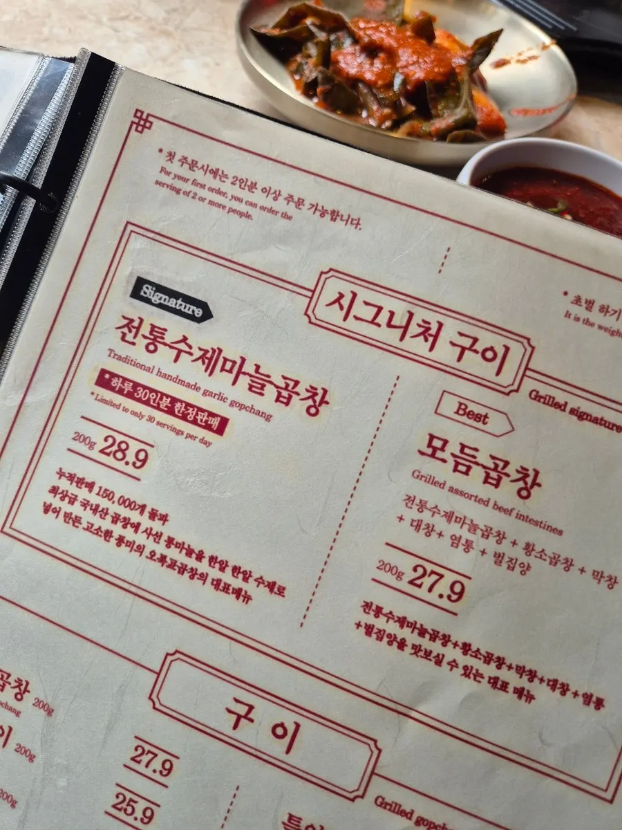 Framed sign recommending garlic gopchang and green onion kimchi