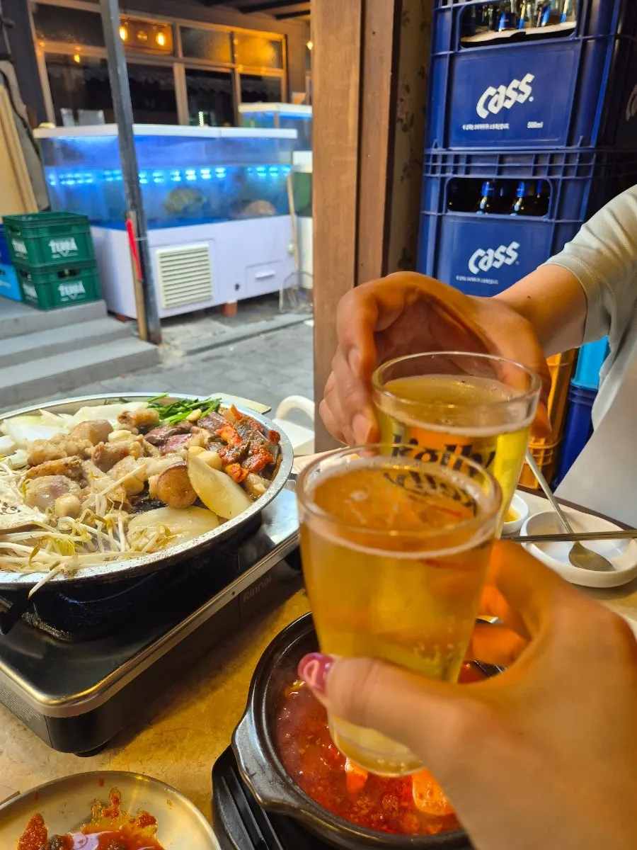 A glass of beer-soju cocktail alongside the gopchang