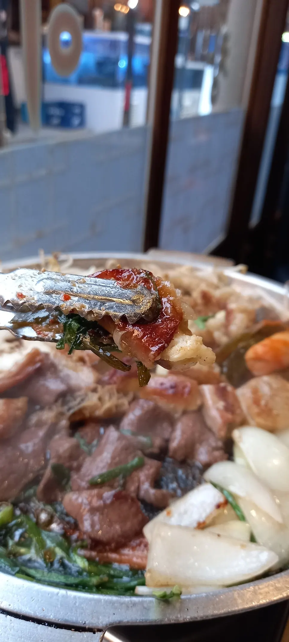 Gopchang and vegetables cooking on the griddle