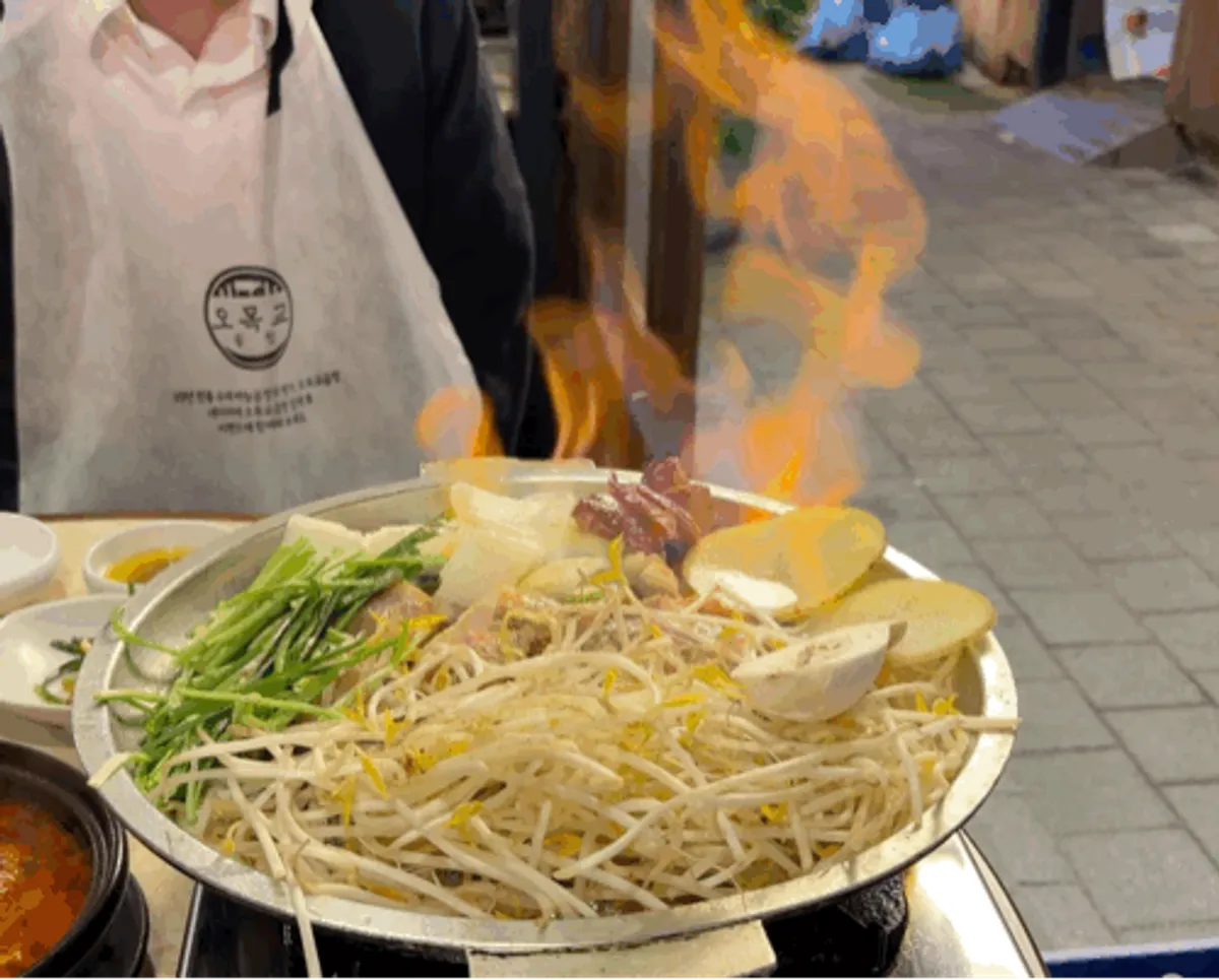 Mixed gopchang and green onion kimchi on the grill