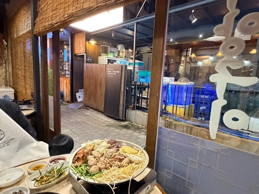 Gopchang grill with bean sprouts and mushrooms on the side