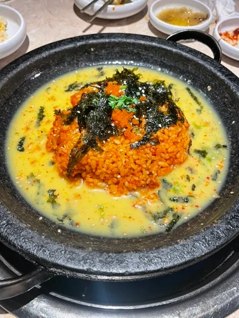A plate of Omokgyo fried rice with beaten egg poured around it
