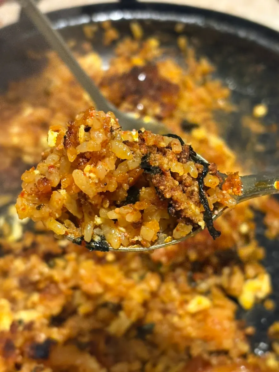 A spoonful of fried rice topped with flying fish roe