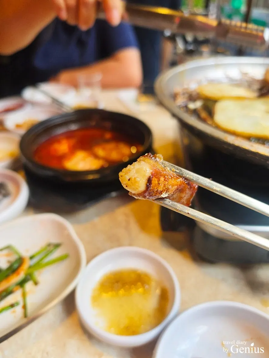 집게로 집어 올린 구운 곱창