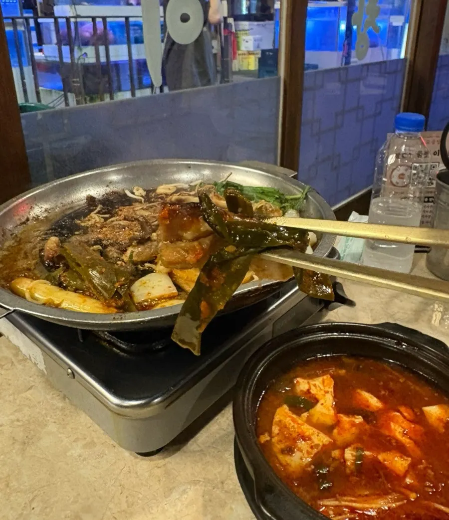 A piece of gopchang dipped in the special sauce