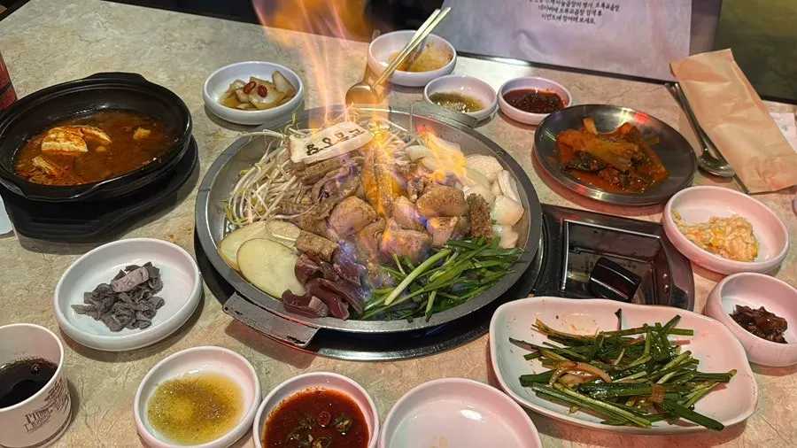 불판 위 곱창에 불을 올리는 초벌 장면