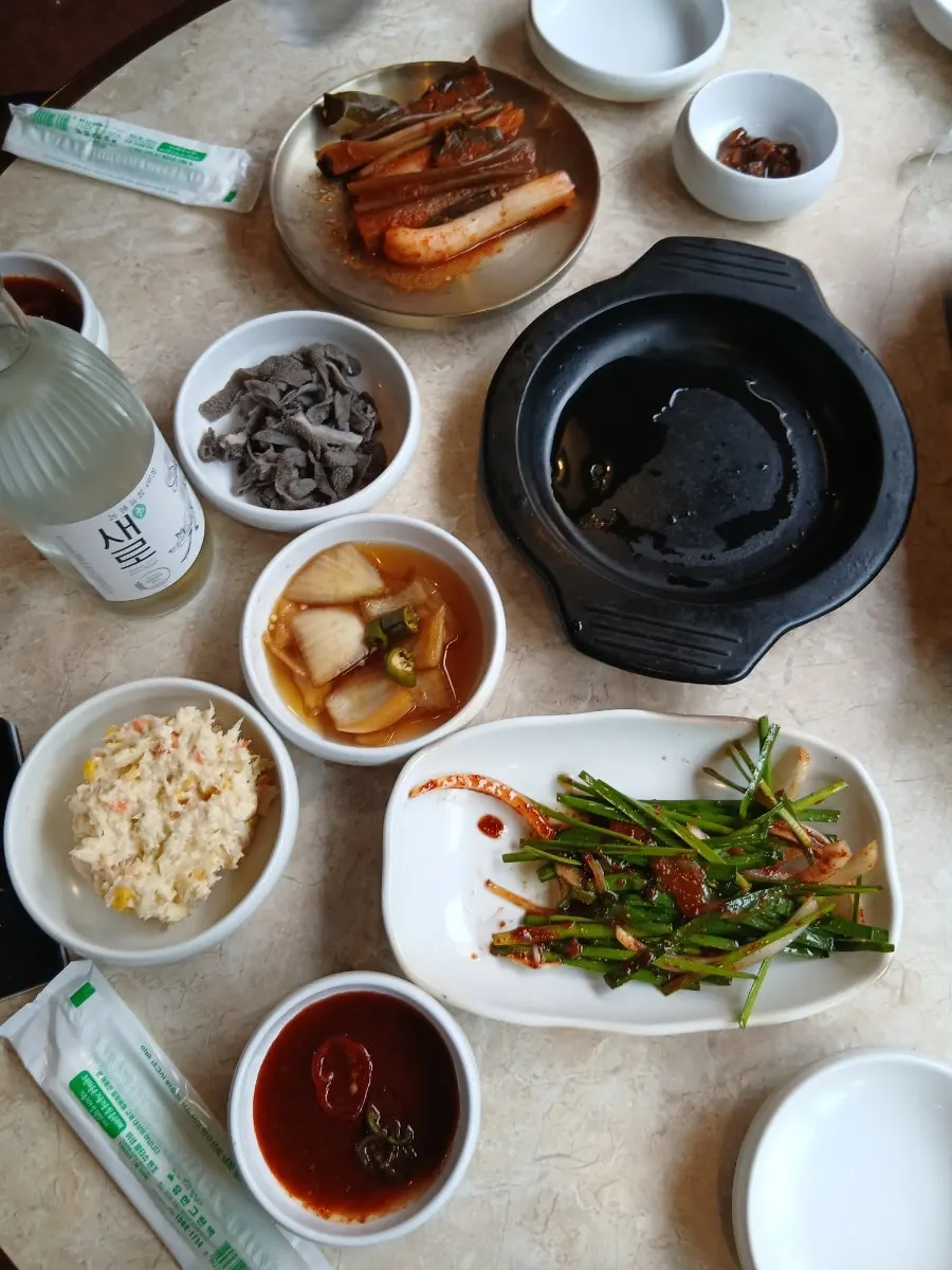 Bubbling sundubu-jjigae next to a soju glass
