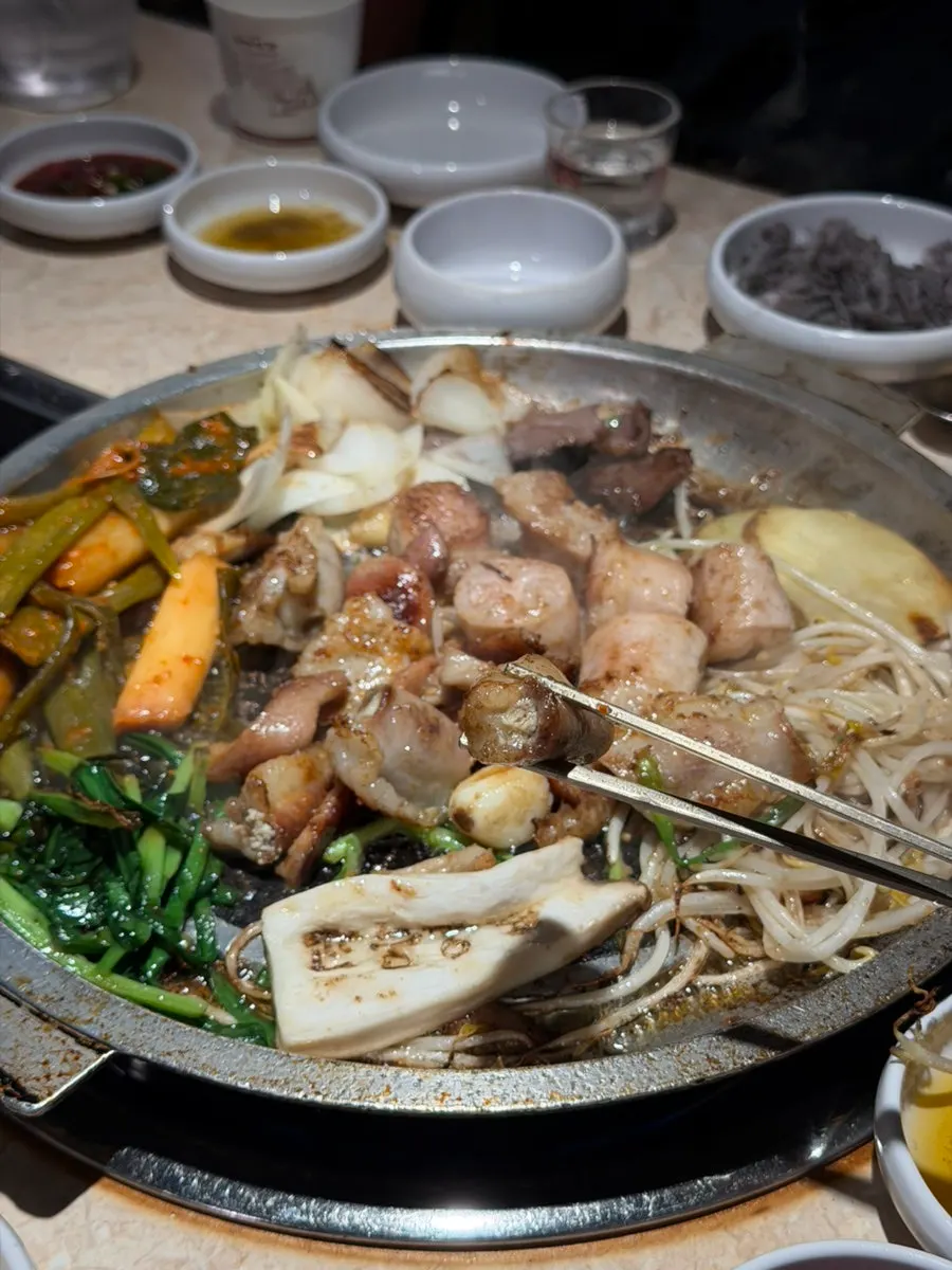 A piece of gopchang topped with green onion kimchi