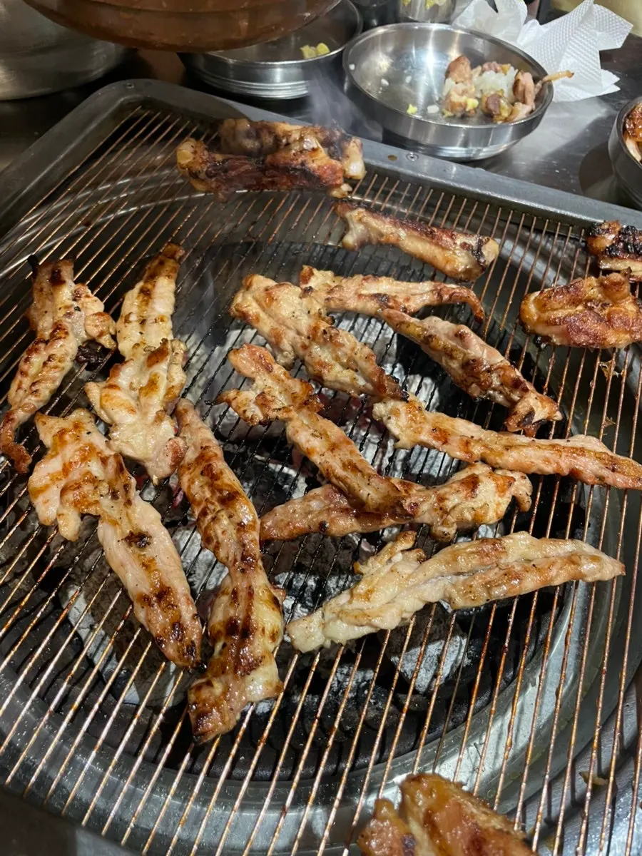 Chicken neck meat grilling over charcoal