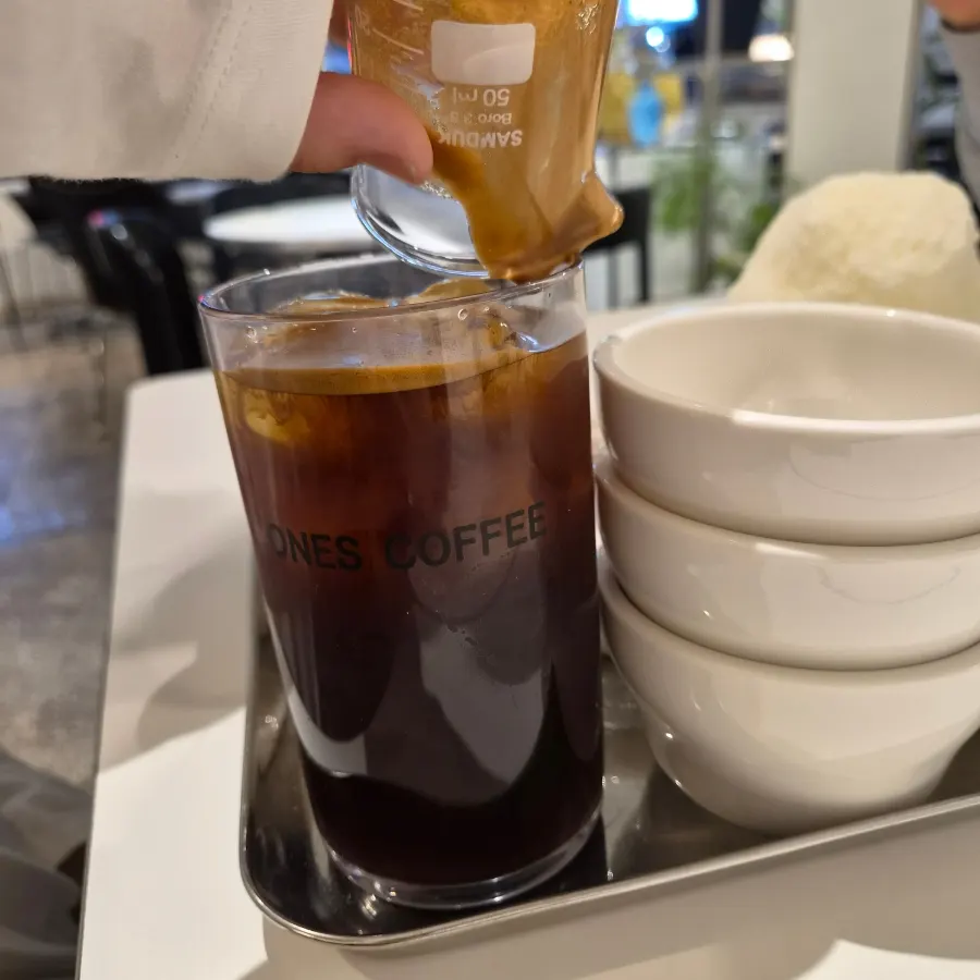 Iced americano in nutty flavor with a separate shot