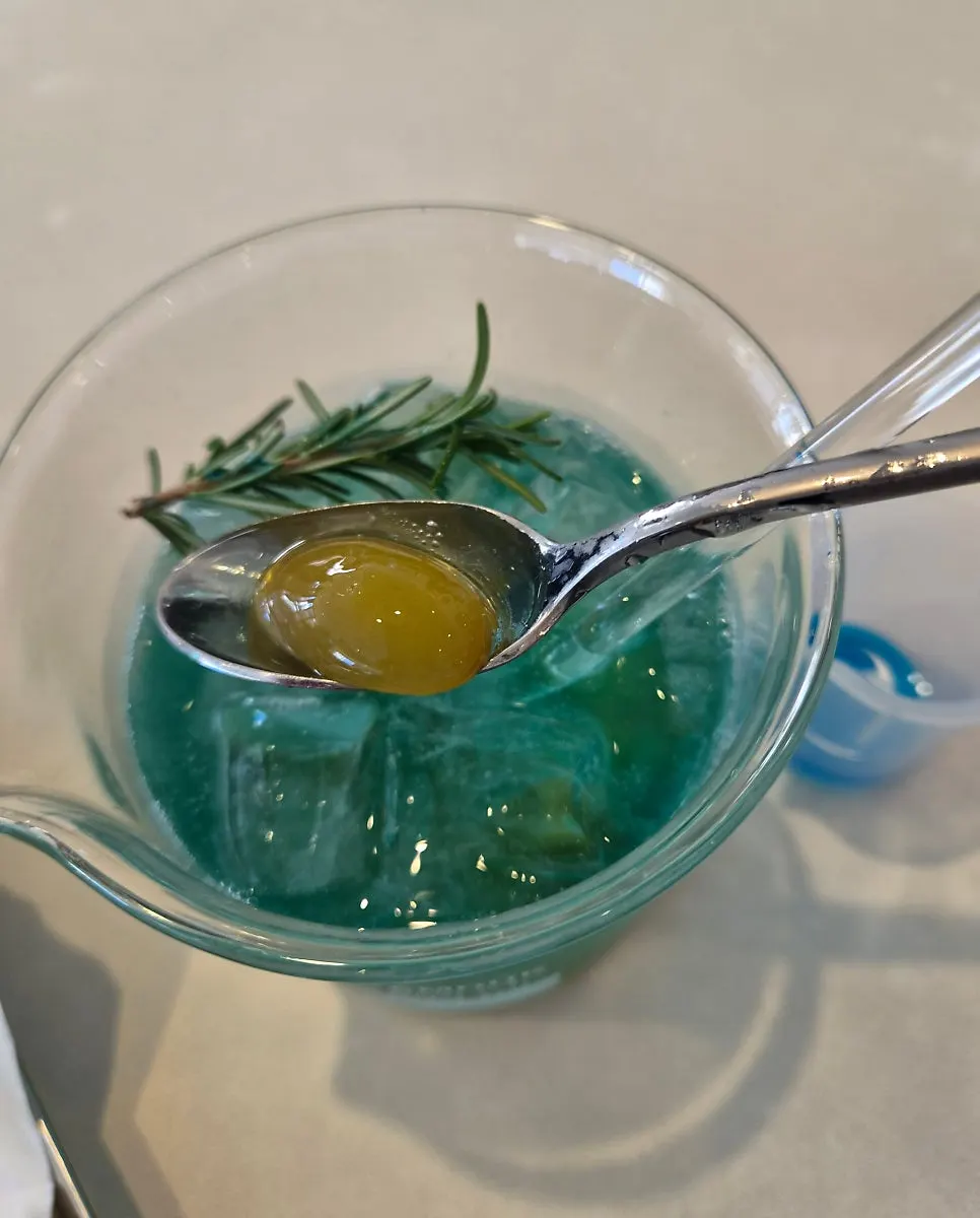 Green grape ade served with a separate blue liquid