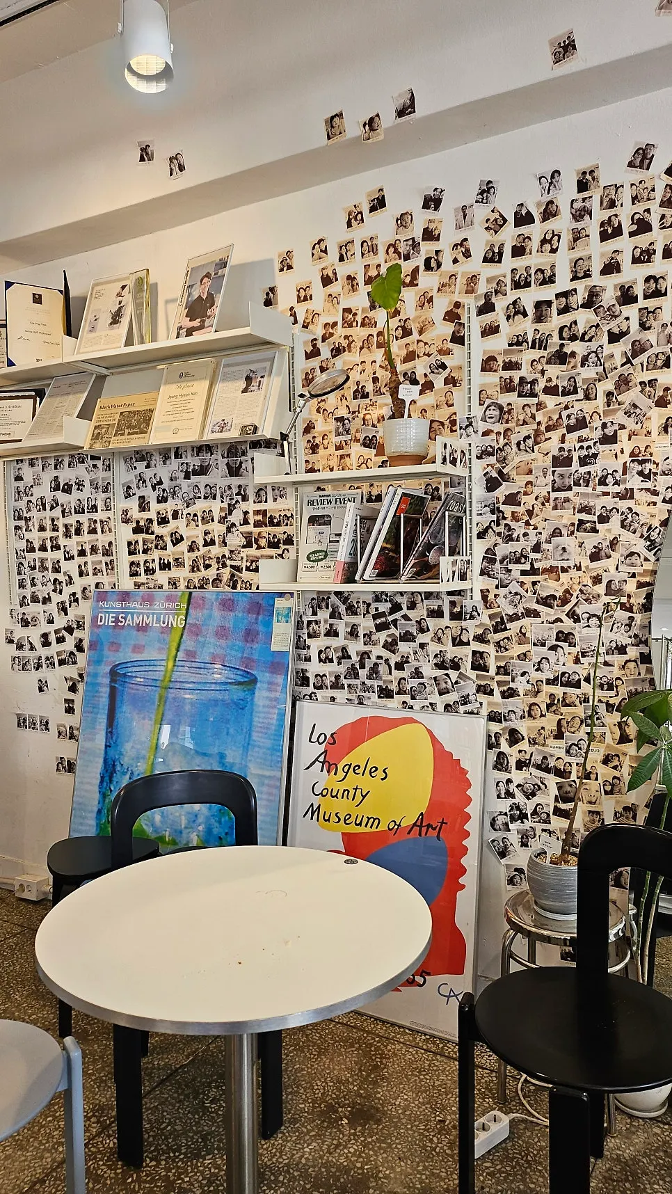 Wall covered in regulars' instant photos at Wonz Coffee
