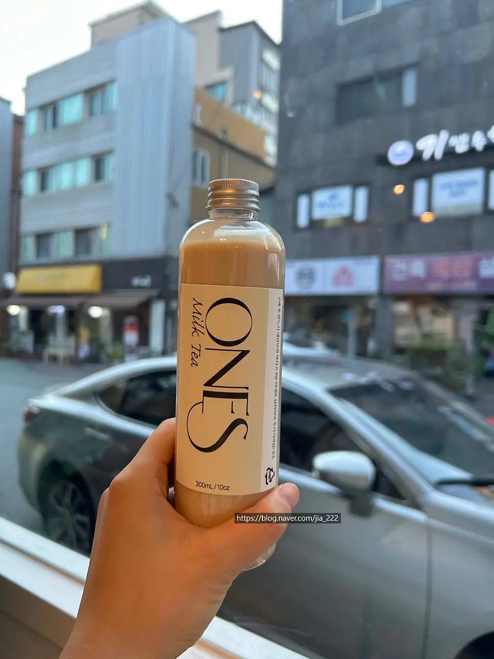 보틀에 담긴 원즈커피 수제 밀크티와 얼음컵