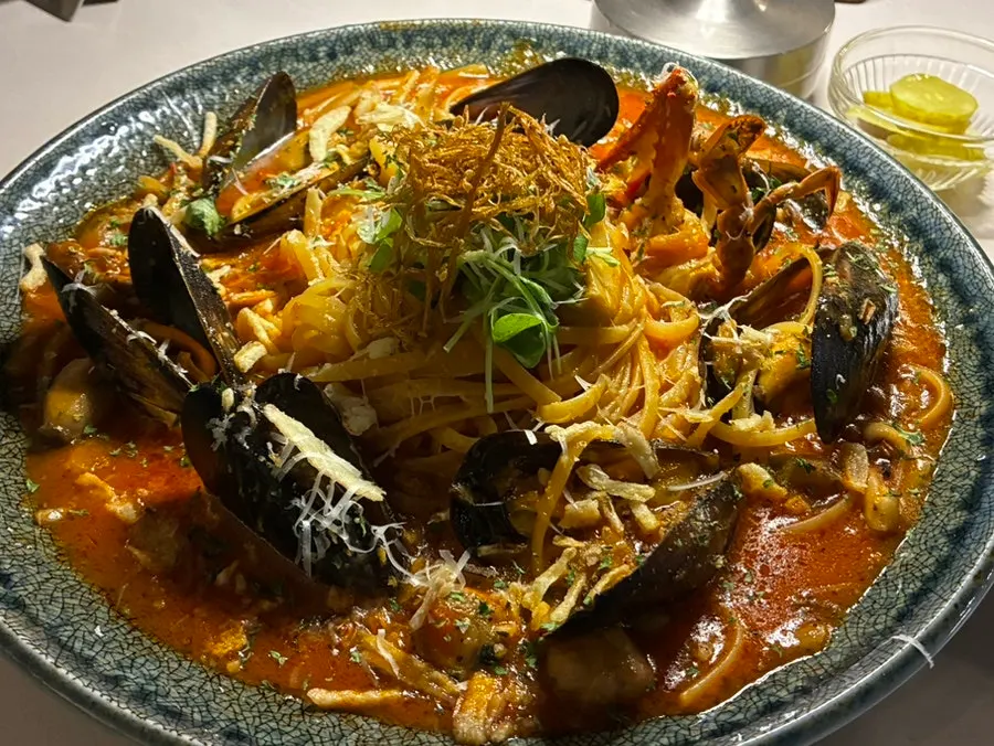 Close-up of arrabbiata topped with crab and mussels