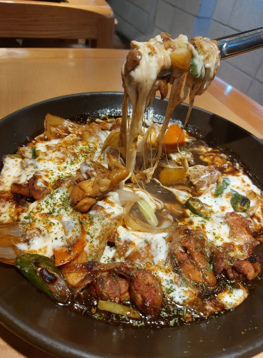 用筷子夾起的起司與去骨雞肉