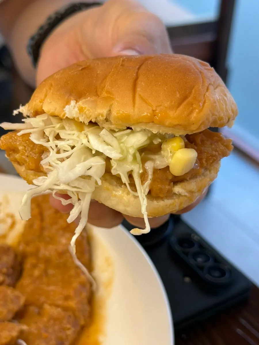 A sandwich made with bread, salad, and pork cutlet