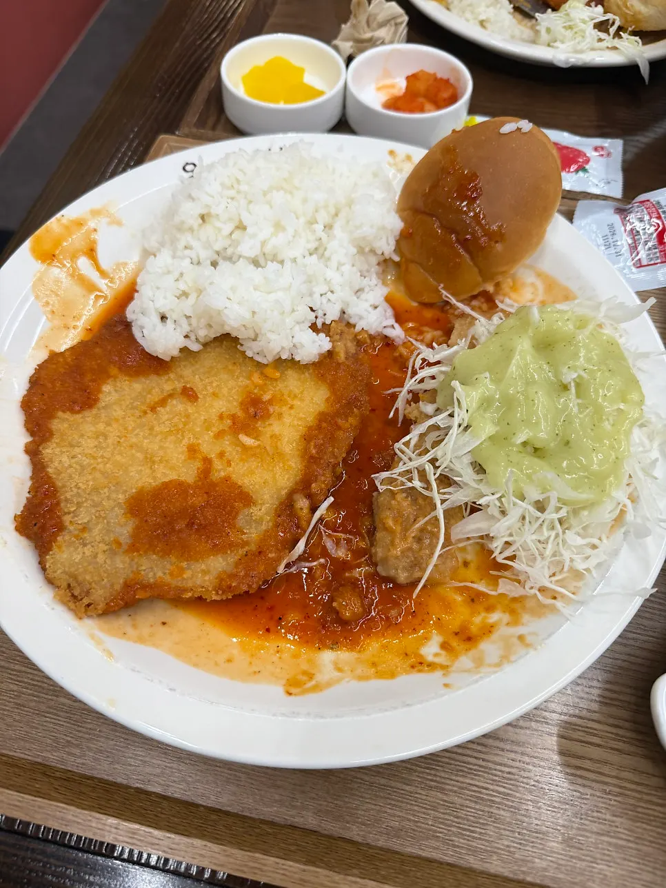 Spicy pork cutlet with rice, salad, and dinner rolls